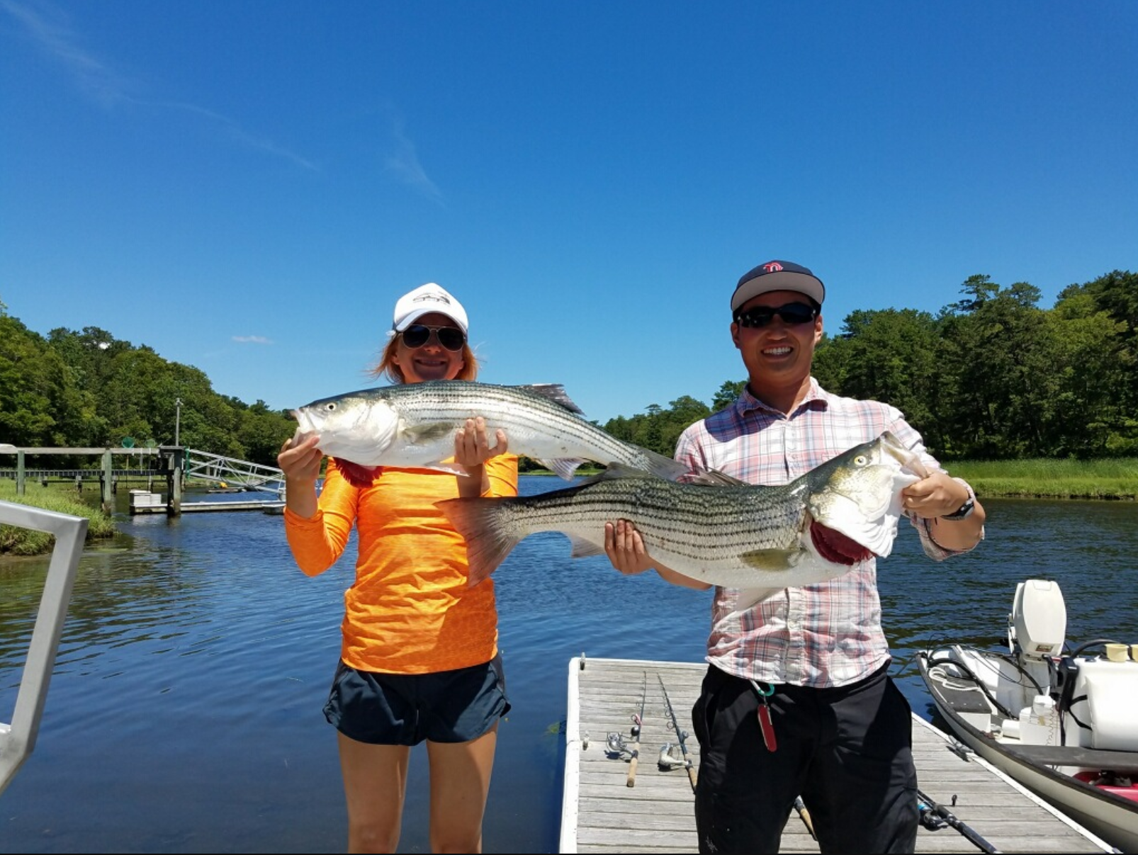 two fishermen holding up caught fish